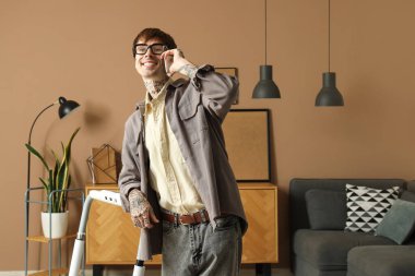 Ofiste koşu bandının yanında cep telefonuyla konuşan genç adam.