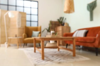 Oturma odası, turuncu kanepe ve masa bulanık görünüyor.