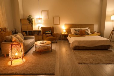 Rahat koltuğu, kanepesi ve yatağı olan şık bir yatak odası.