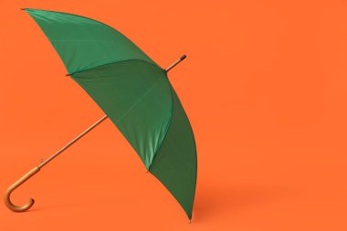 Turuncu arka planda zarif yeşil şemsiye