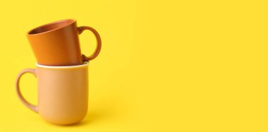 Sarı zemin üzerinde seramik bardaklar ve metin için boşluk