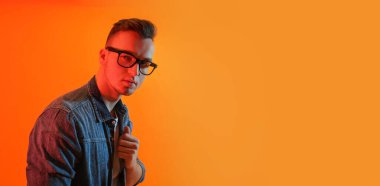 Turuncu arka planda yakışıklı bir gencin tonlu portresi ve metin için yeri var.