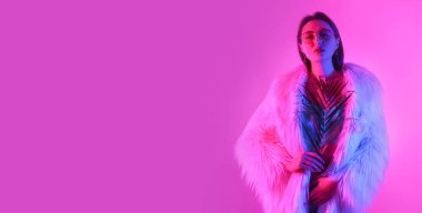 Parlak arka planda tropikal yaprak tutan zarif genç bir kadının tonlu portresi.