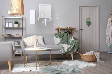 Kapısında ve tavanında kanepe, sehpa ve düş kapanı asılı modern oturma odası.