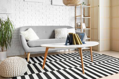 Interior of room with shelving unit and stylish holder for books on table clipart