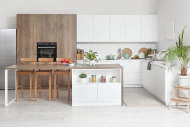Ada masası ve beyaz tezgahlı modern mutfak.