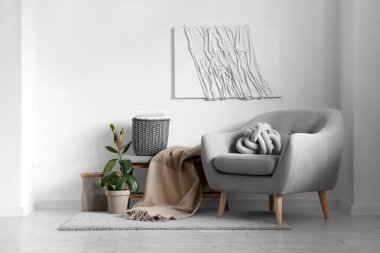 Koltuk ve hasır sepetli, aydınlık oturma odasının içi