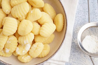 Lezzetli gnocchi tabağı ve arka planda un, yakın plan.