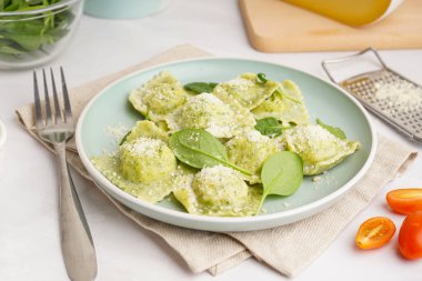 Beyaz zemin üzerinde peynir olan lezzetli bir ravioli tabağı.