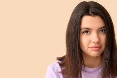 Bej arka planda kepek sorunu olan genç bir kadın.