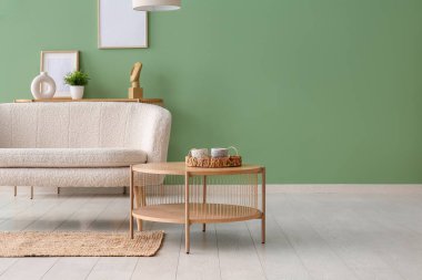 Beyaz kanepesi, kahve masası ve halısı olan oturma odasının içinde.