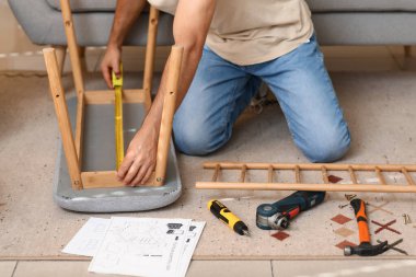 Evde mezura montajı yapan genç adam, yakın plan.