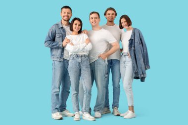 Mavi arka planda kot giymiş bir grup genç.