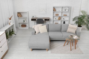 Oturma odasının iç tarafında rahat bir kanepe ve cam sehpa.