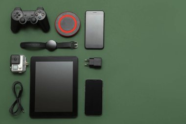 Koyu yeşil zemin üzerinde modern aygıtlar kümesi, üst görünüm