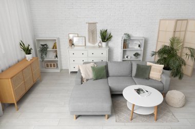 Oturma odasının içinde masa, puf ve rahat bir kanepe.