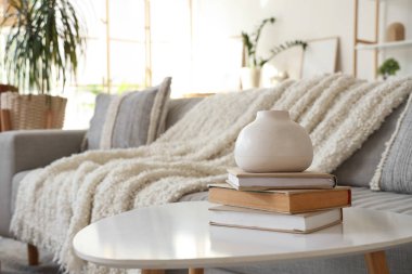 Oturma odasında kitaplarla dolu vazo, yakın plan.