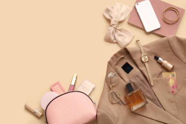 Renkli arka planda dekoratif kozmetik, aksesuarlar, kıyafetler ve cep telefonuyla kompozisyon