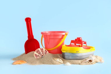 Plaj oyuncakları ve açık mavi arka planda kum