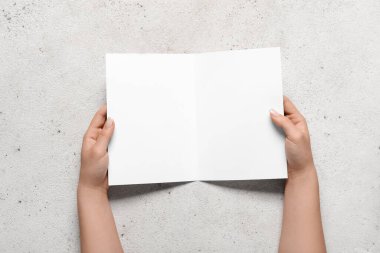 Beyaz arka planda boş broşürlü kadın elleri