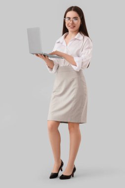 Dizüstü bilgisayarla çalışan genç sekreter.