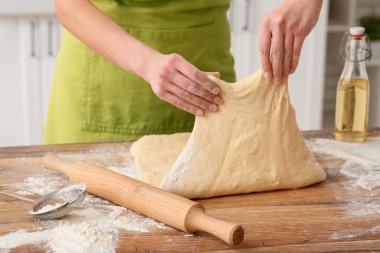 Mutfakta taze hamur yoğuran bir kadın