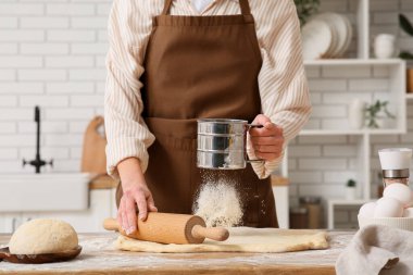 Mutfakta taze hamur yoğuran bir kadın