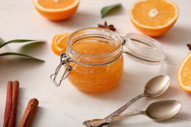 Beyaz ahşap arka planda lezzetli turuncu reçel kavanozu