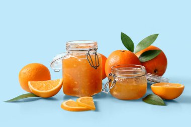 Açık mavi arkaplanda lezzetli turuncu reçel kavanozları