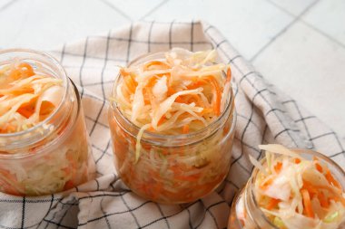 Peçetede lezzetli lahana turşusu olan cam kavanozlar. Yakın çekim.