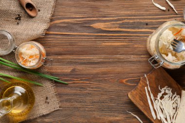 Lezzetli lahana turşulu cam kavanoz ve ahşap masa malzemeleri. Üst görünüm