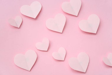 Paper hearts on pink background. Valentine's Day celebration