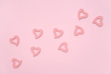 Pembe arka planda kalp şeklinde dekorasyonlar. Sevgililer Günü kutlaması