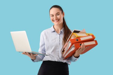 Dizüstü bilgisayarı ve mavi arkaplanı olan güzel sekreter.