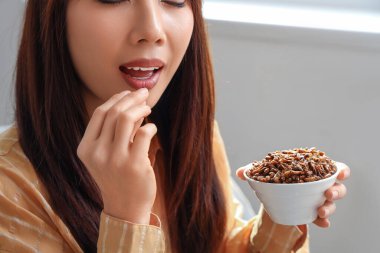 Evde kızarmış böcek yiyen genç bir kadın, yakın plan.