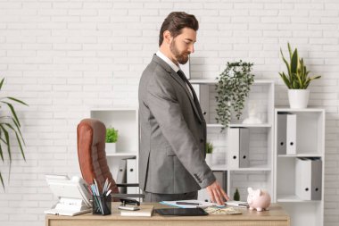 Ofiste çalışan, hesap makineli genç bir iş adamı.