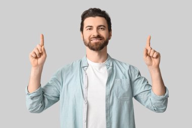 Genç adam ışık arkaplanını işaret ediyor