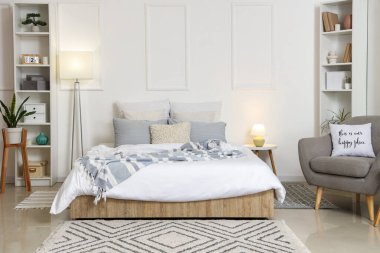 Şık lamba yatak odası, rahat yatak odası, gri koltuk ve parlak lambalar.