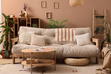 Kanepesi, masası ve bitkileri olan şık bir oturma odası.