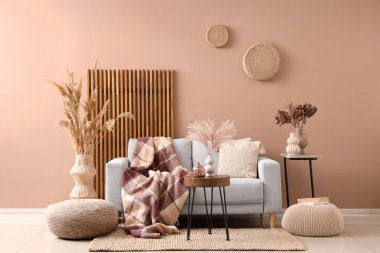 Kanepesi, masaları ve kuru sazlıkları olan şık bir oturma odası.