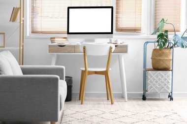 Işık odası içerisindeki pencerenin yanında boş bilgisayar monitörü olan işyeri