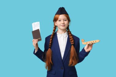 Pasaportu ve mavi arka planda ahşap uçağı olan genç hostes.
