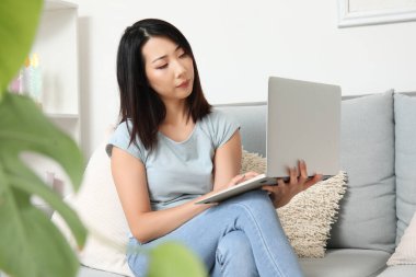 Bilgisayarlı güzel Asyalı kadın evde İngilizce öğreniyor.