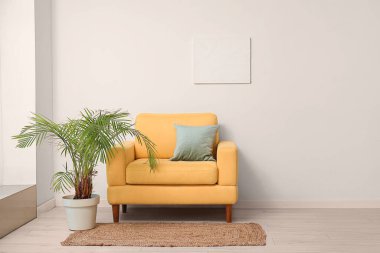 Oturma odasının içinde palmiye ağacı ve koltuk var.