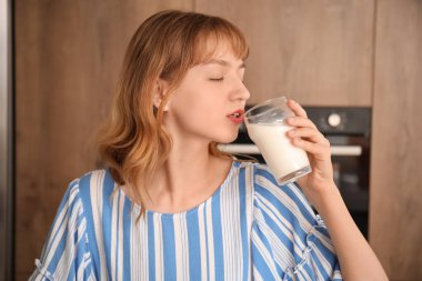 Mutfakta süt içen genç bir kadın, yakın plan.