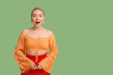 Yeşil arka planda mutlu genç bir kadın