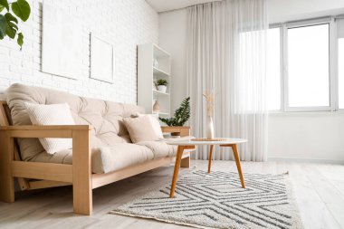 Rahat kanepesi, çiçekleri ve beyaz mobilyaları olan aydınlık oturma odasının içinde.