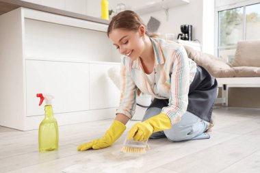 Mutfakta fırçayla yerleri temizleyen kadın hademe.