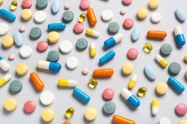 Gri arka planda farklı renkli haplar.