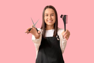 Makasla kadın kuaför ve pembe arka planda fırça.